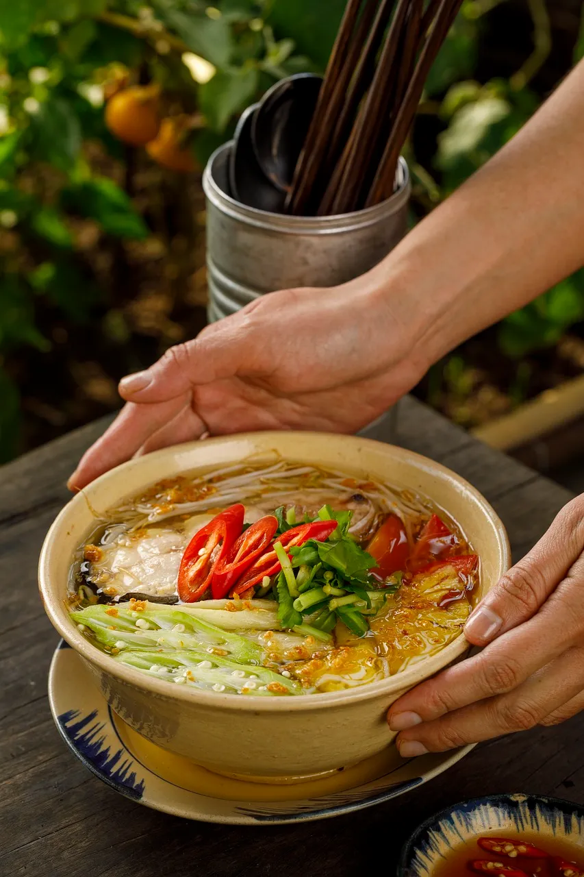 Hands serving Vietnamese Pho